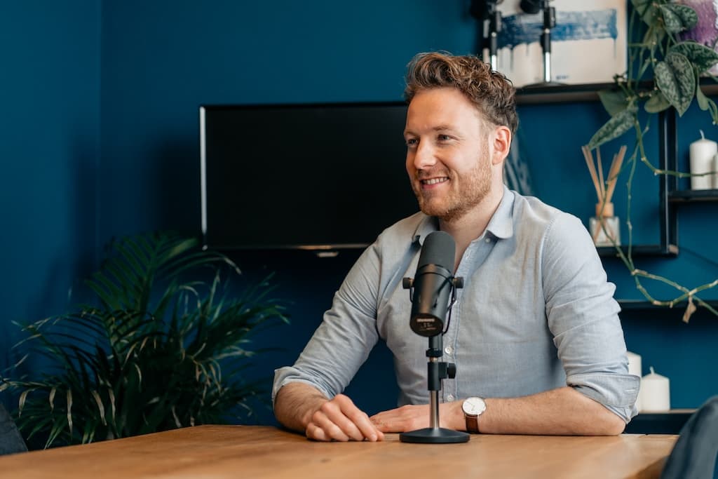 Rudy Nicola achter de microfoon in de podcaststudio